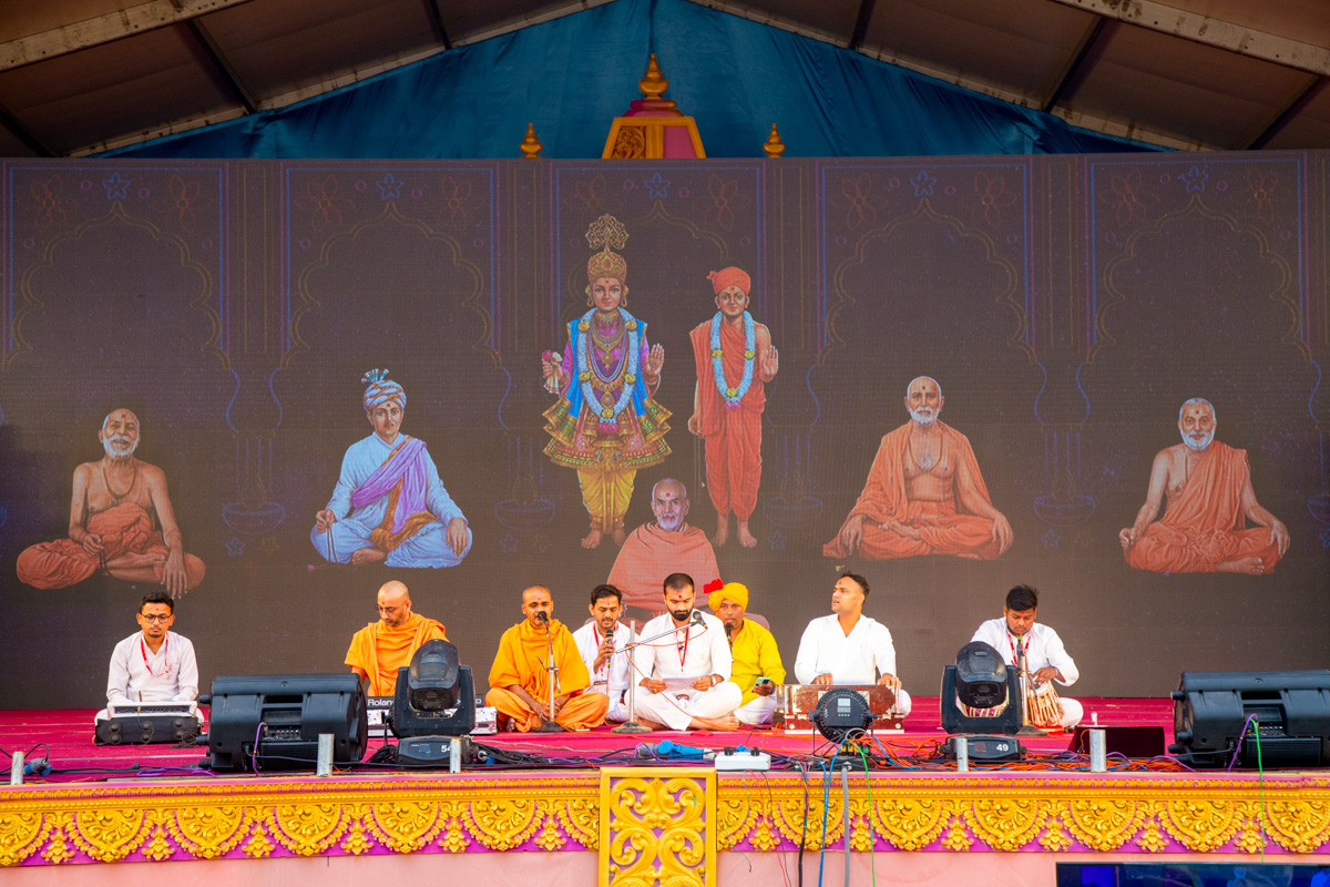 Swamis and youths sing kirtans in the evening assembly