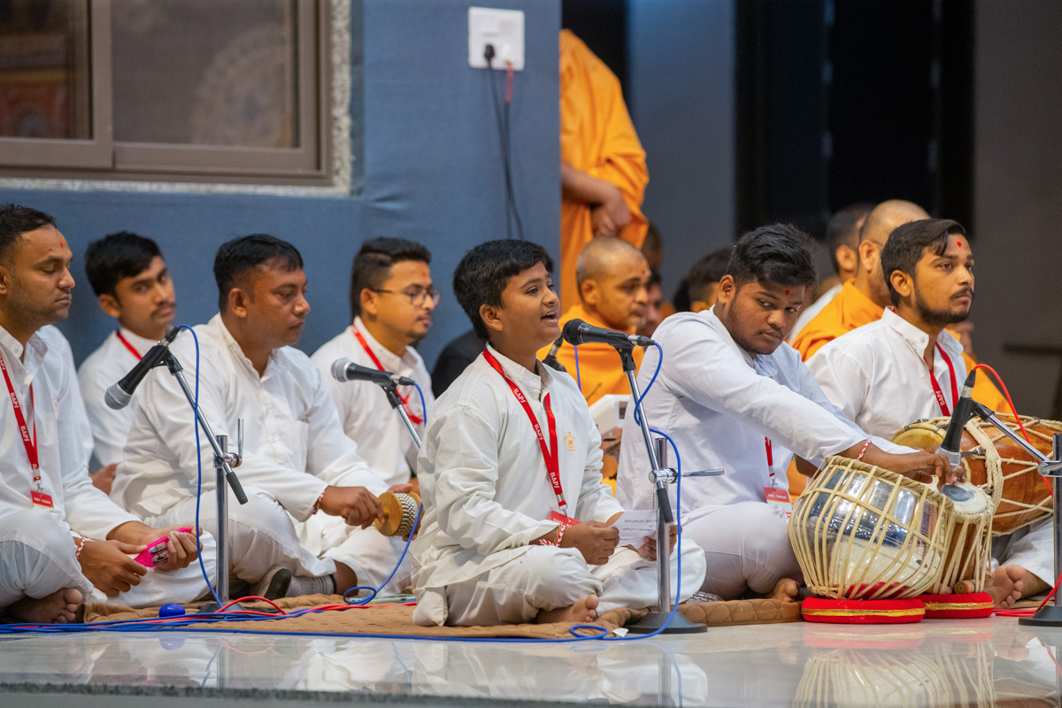 A child sings a kirtan in Swamishri's puja