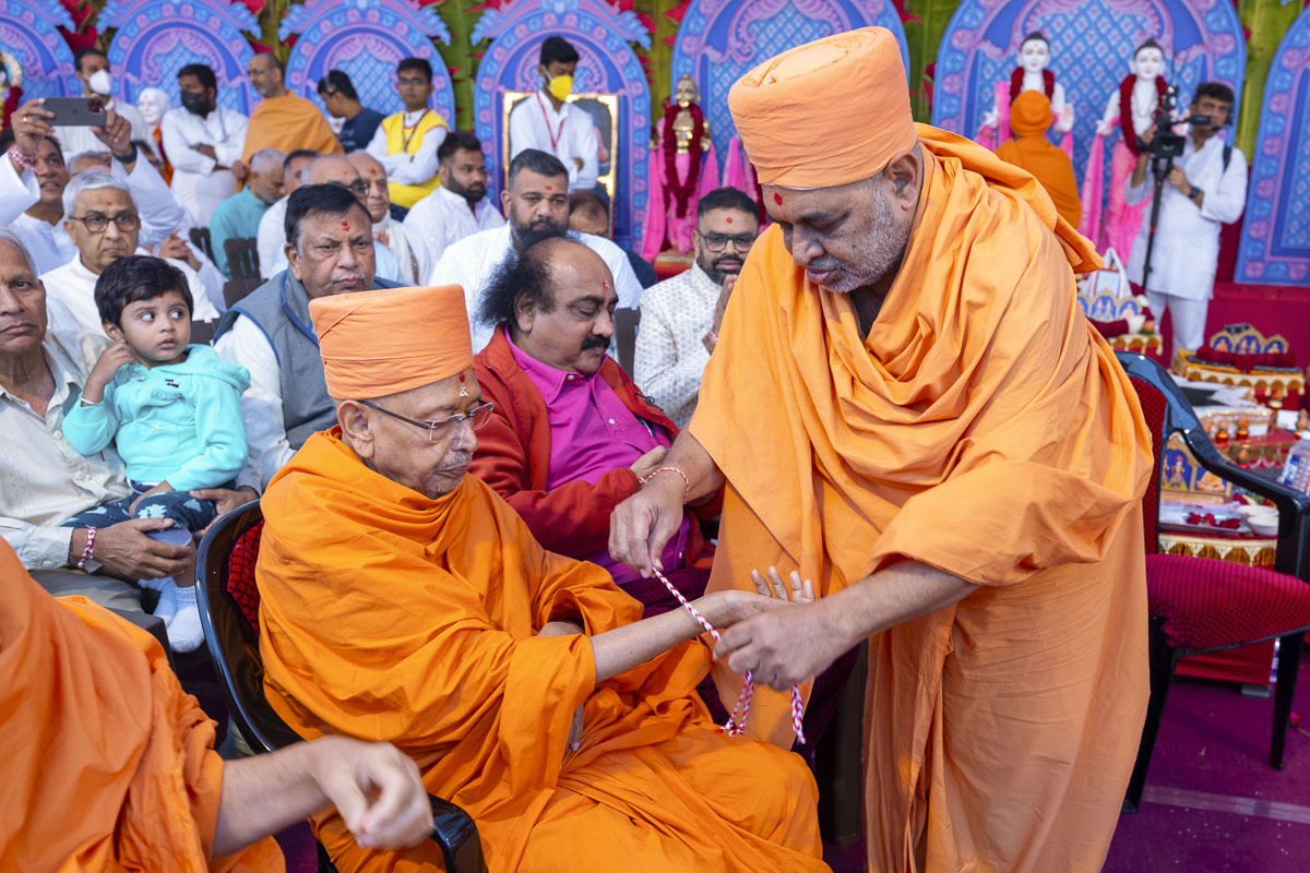 Bhagwatcharan Swami ties a nadachhadi to Pujya Tyagvallabh Swami