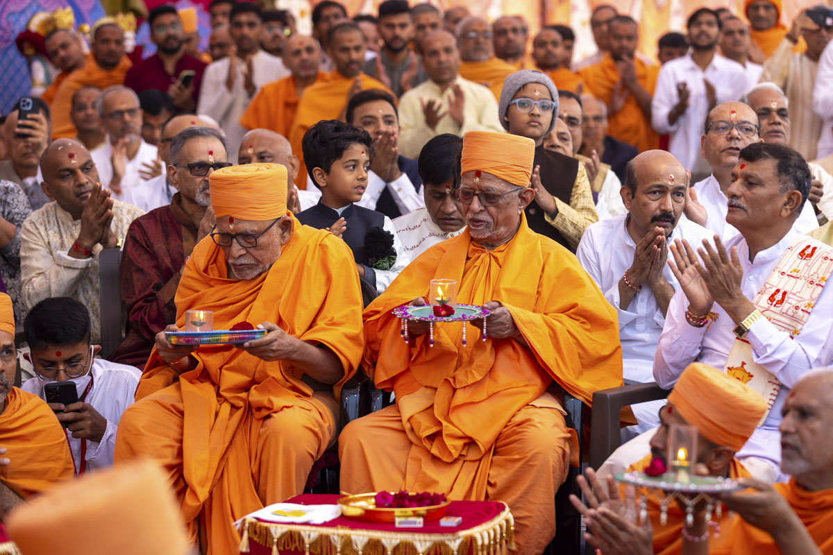 Pujya Doctor Swami and Pujya Kothari Swami perform the yagna arti