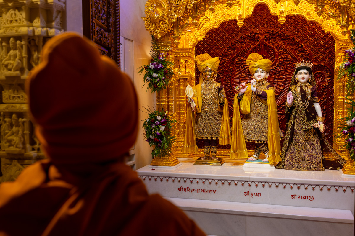Swamishri engrossed in darshan of Shri Harikrishna Maharaj, and Shri Krishna Bhagwan and Radhaji