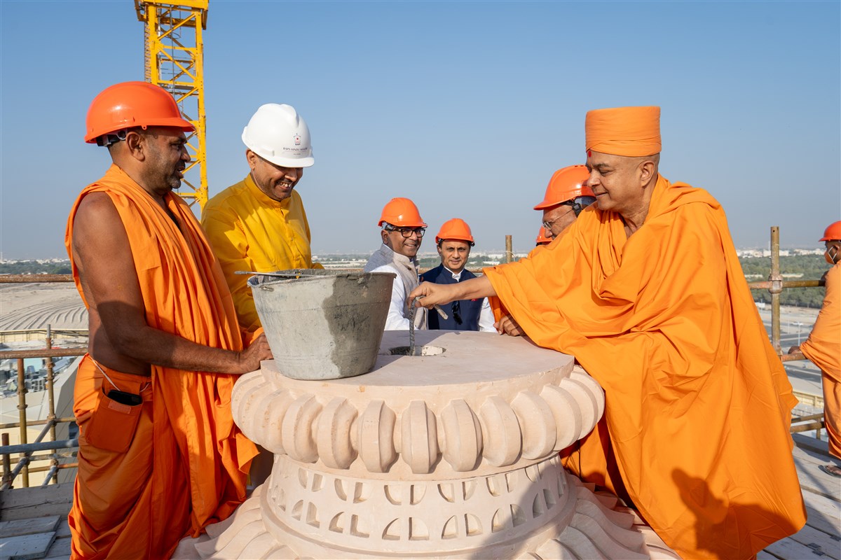 Swami Brahmaviharidas prepares the main spire for the placement of the first Amrut Kalash