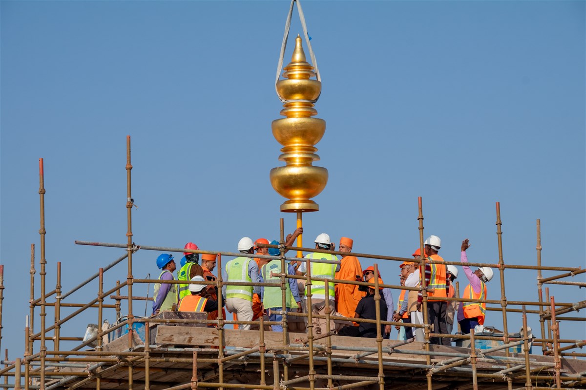 The Amrut Kalash is carefully lowered upon the central spire of the BAPS Hindu Mandir, Abu Dhabi
