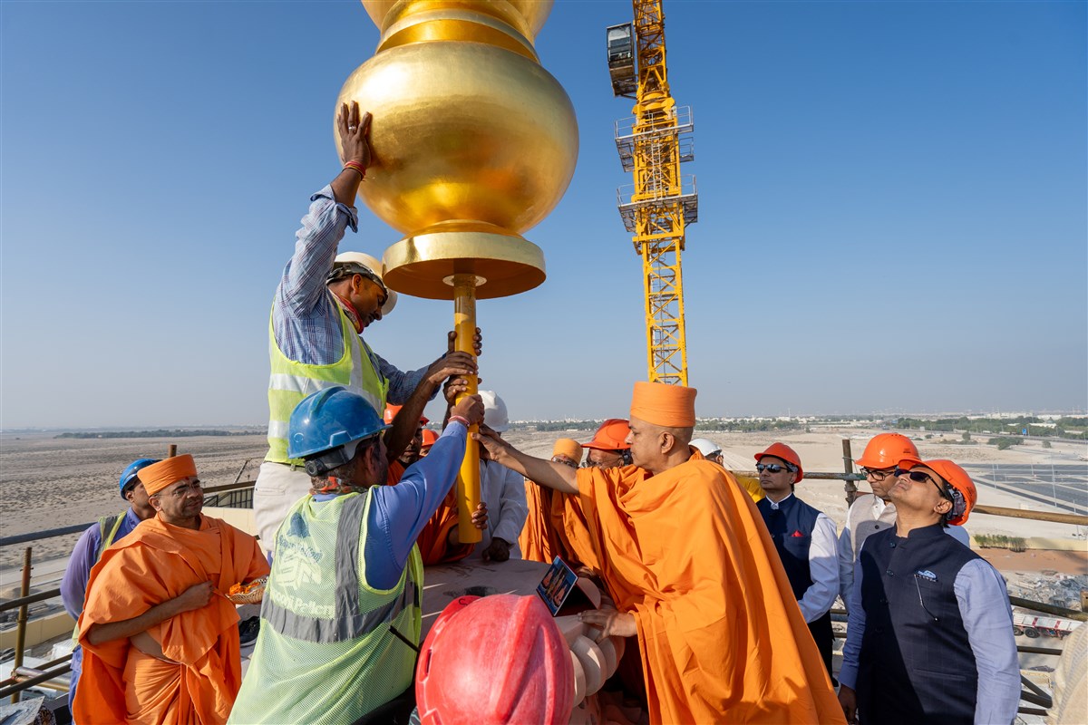 Swamis and volunteers align the Amrut Kalash in its final position