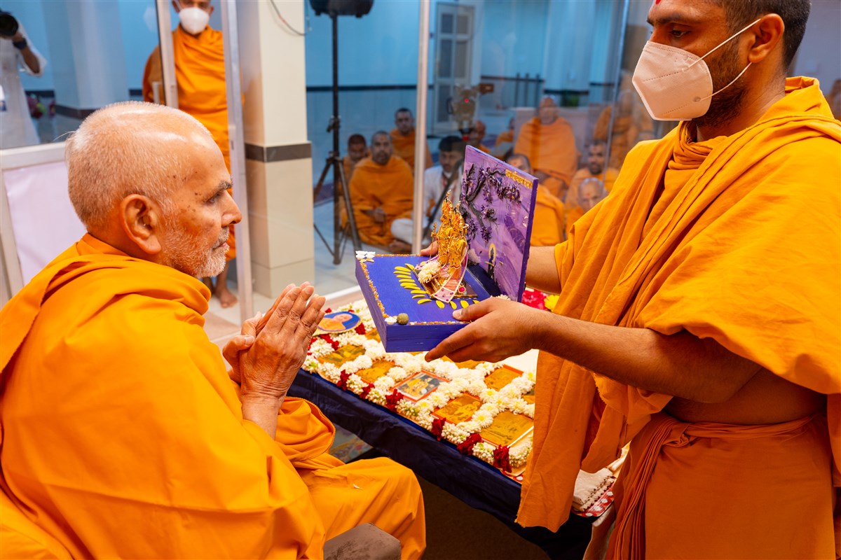 Swamishri engrossed in darshan of Shri Harikrishna Maharaj and Shri Gunatitanand Swami Maharaj 
