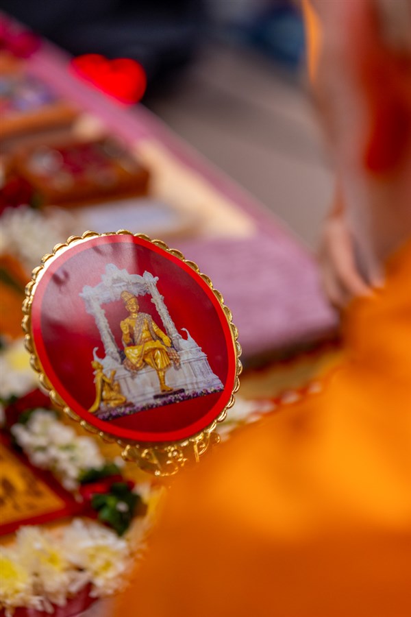 Swamishri engrossed in darshan of Bhagwan Swaminarayan and Aksharbrahma Gunatitanand Swami on the back of the mirror