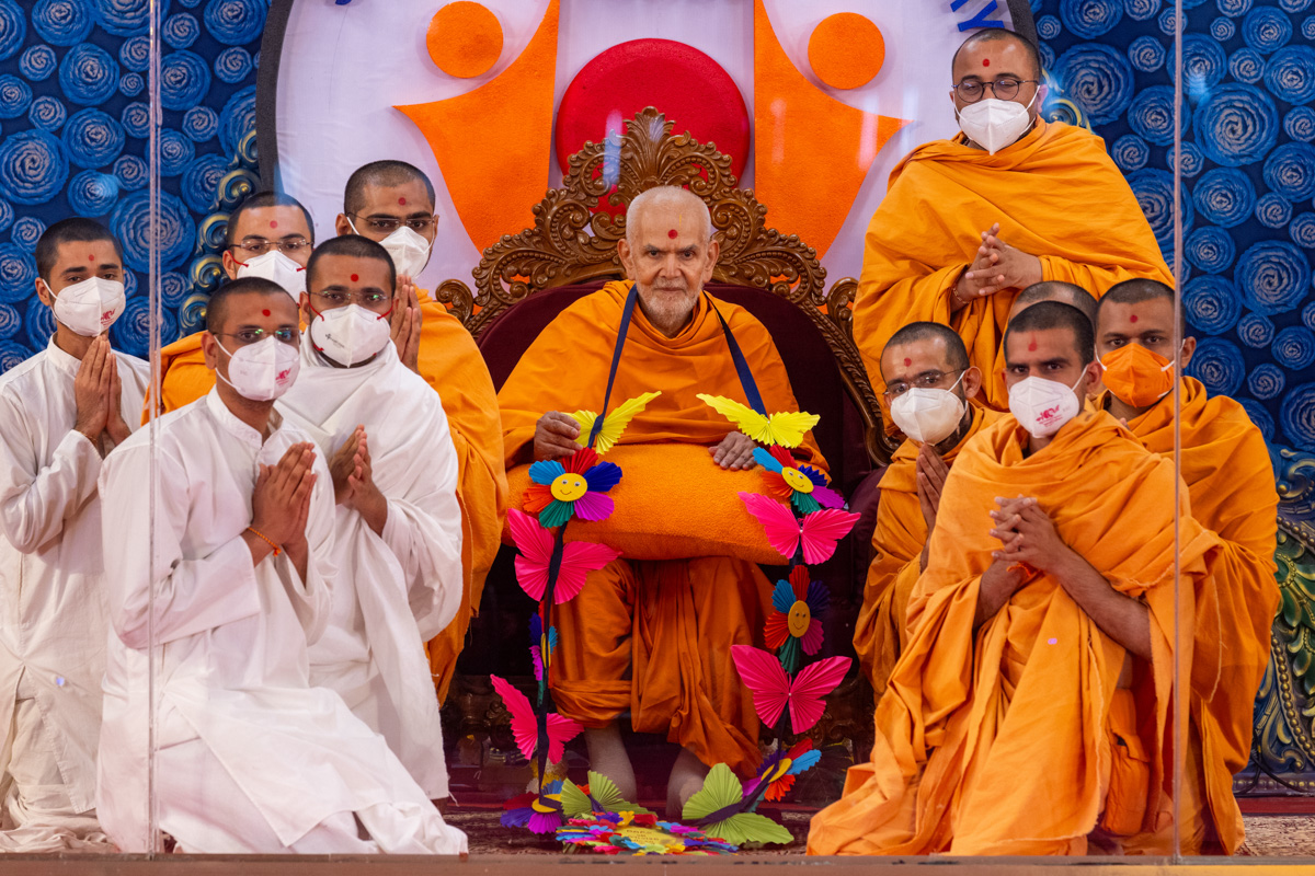 Swamis, parshads and sadhaks honor Swamishri with a garland
