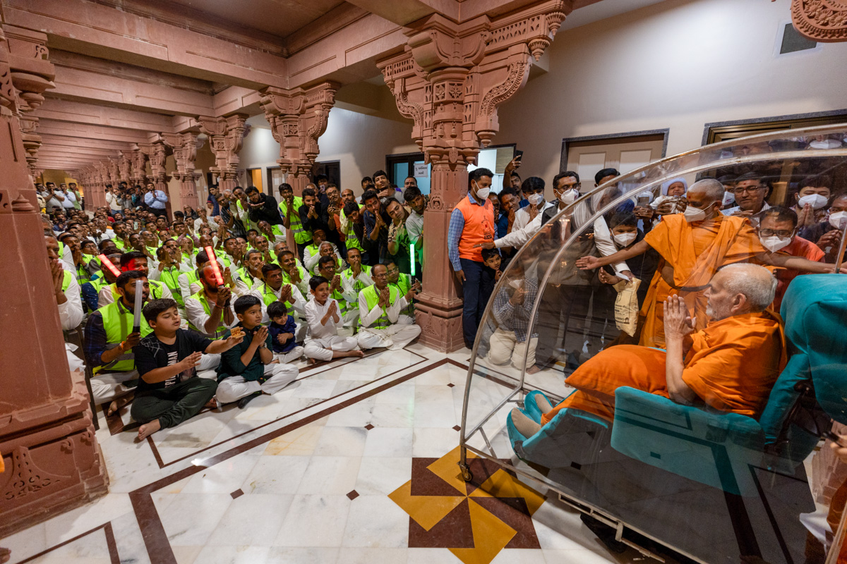 Volunteers and devotees doing darshan of Swamishri
