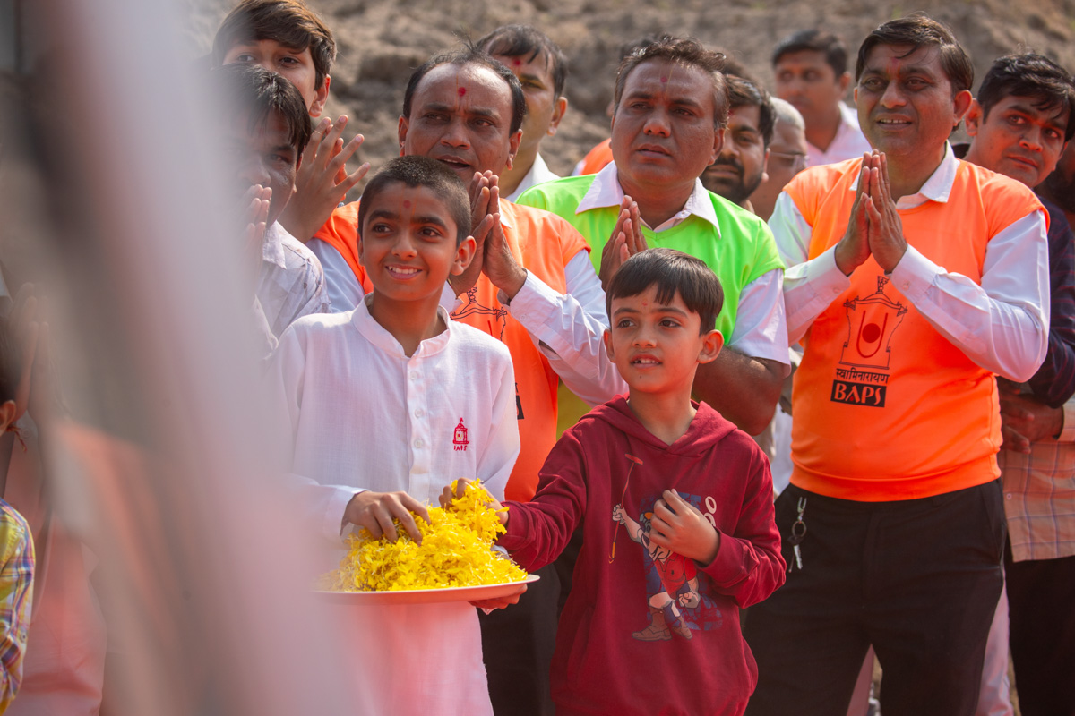 Children welcome Swamishri by showering flower petals