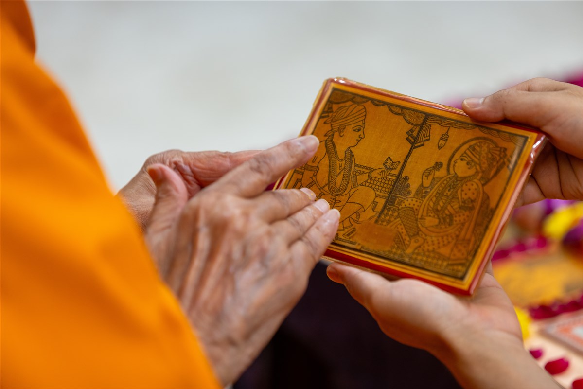 Swamishri reverently touches the holy feet of Bhagwan Swaminarayan and Gunatitanand Swami