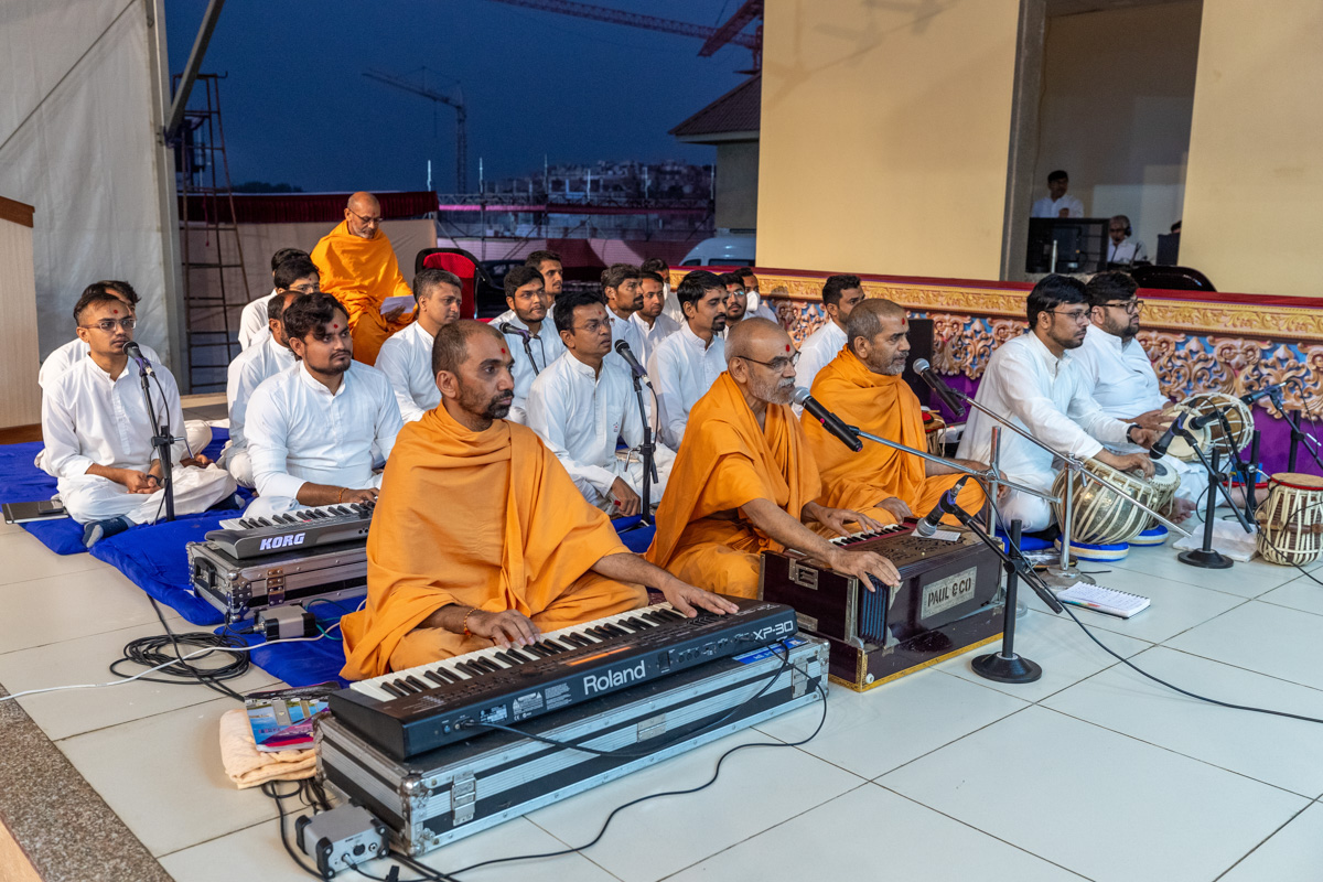 Swamis sing kirtans in Swamishri's daily puja