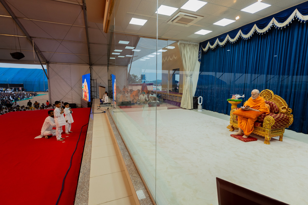 Children leads everyone in reciting the sadhana mantra and daily prayer in Swamishri's puja