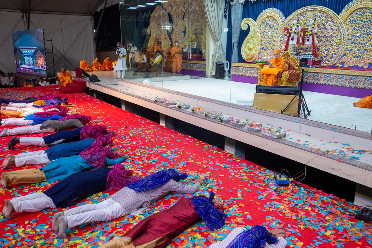 Youths perform dandvats to Swamishri