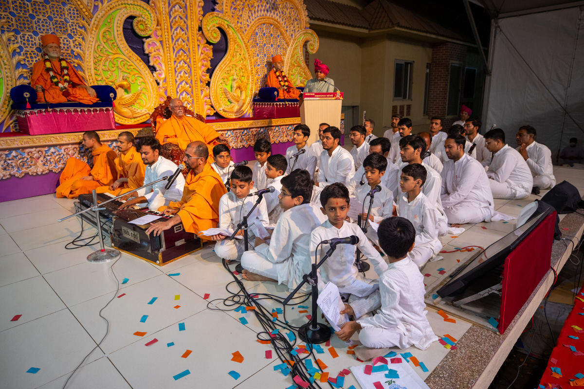 Swamis, youths and children sing kirtans