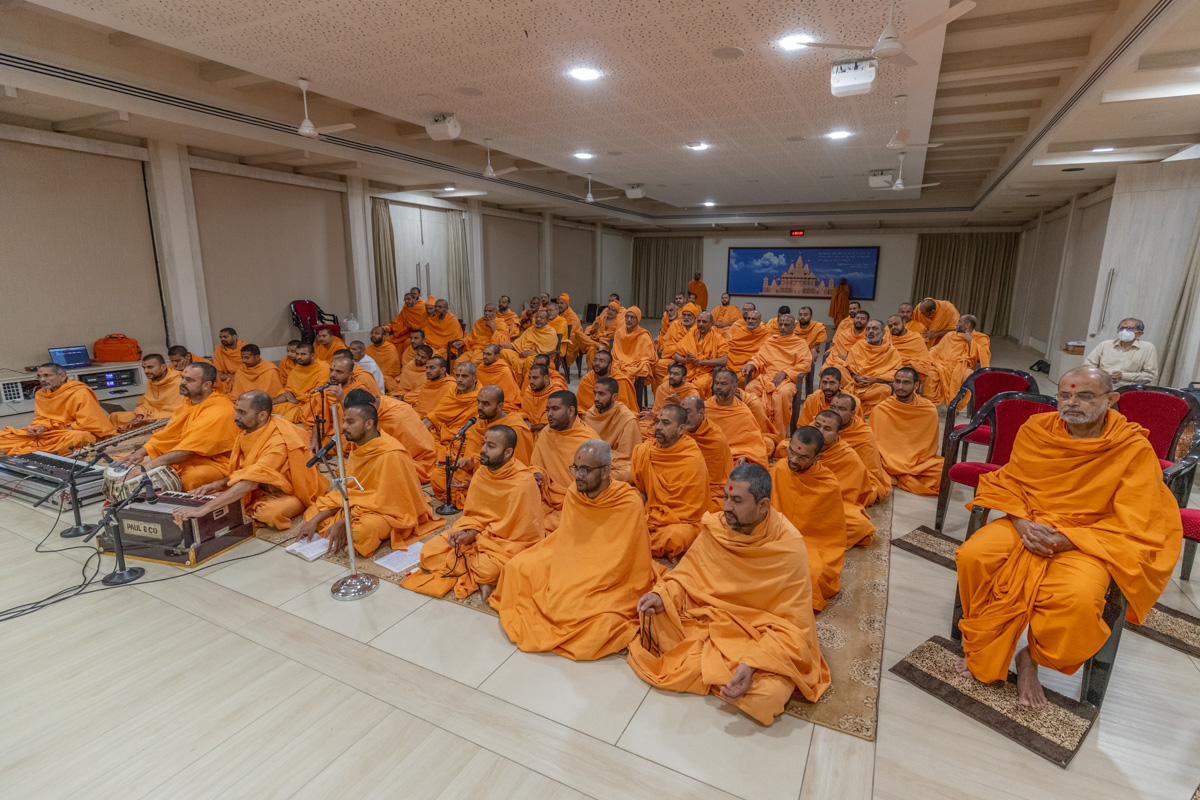 Swamis sing kirtans in Swamishri's puja