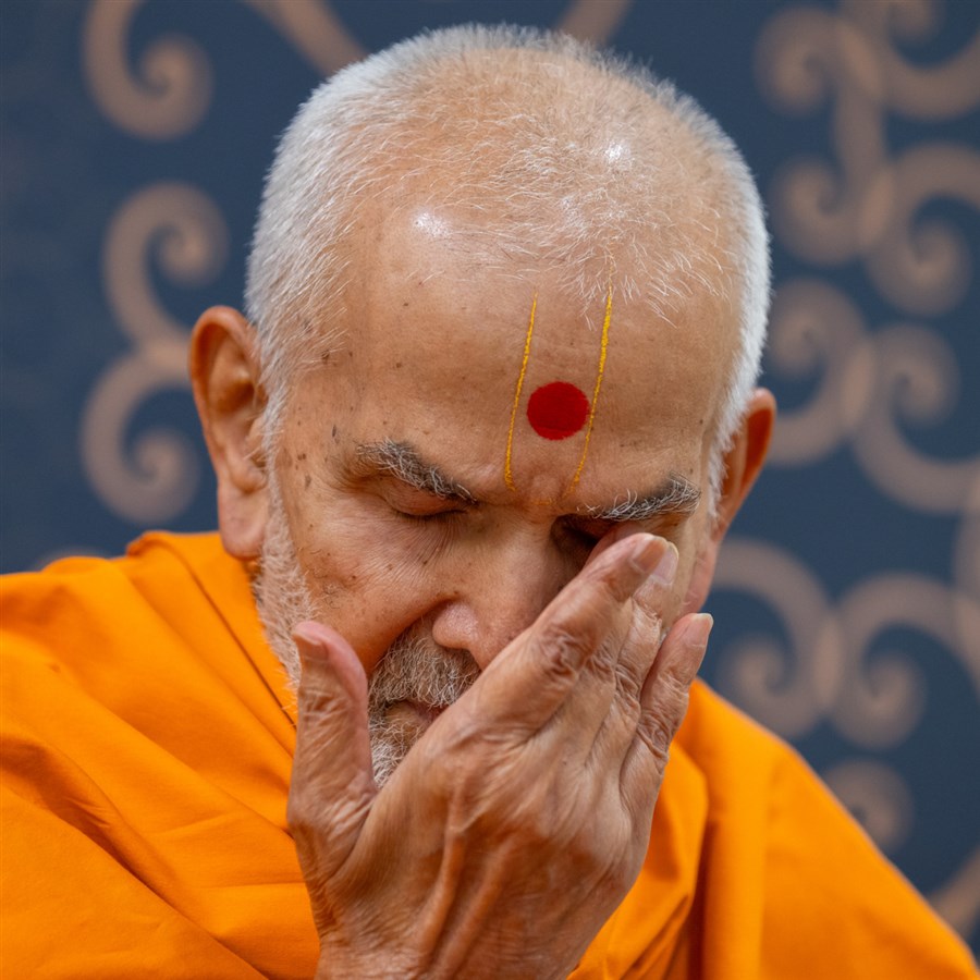 Swamishri reverently touches his eyes after darshan of Shri Akshar-Purushottam Maharaj