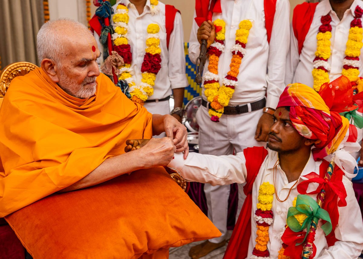 Swamishri ties a nadachhadi to a tribal youth