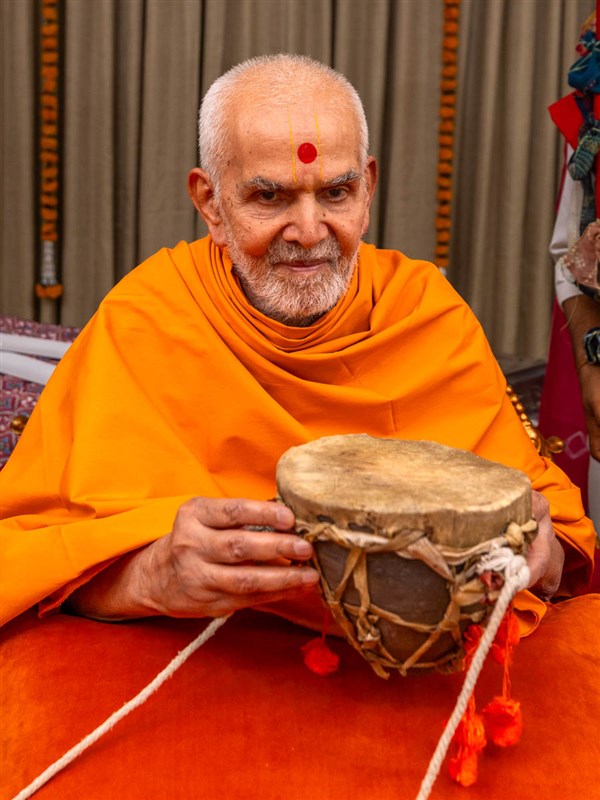 Swamishri sanctifies a traditional tribal drum