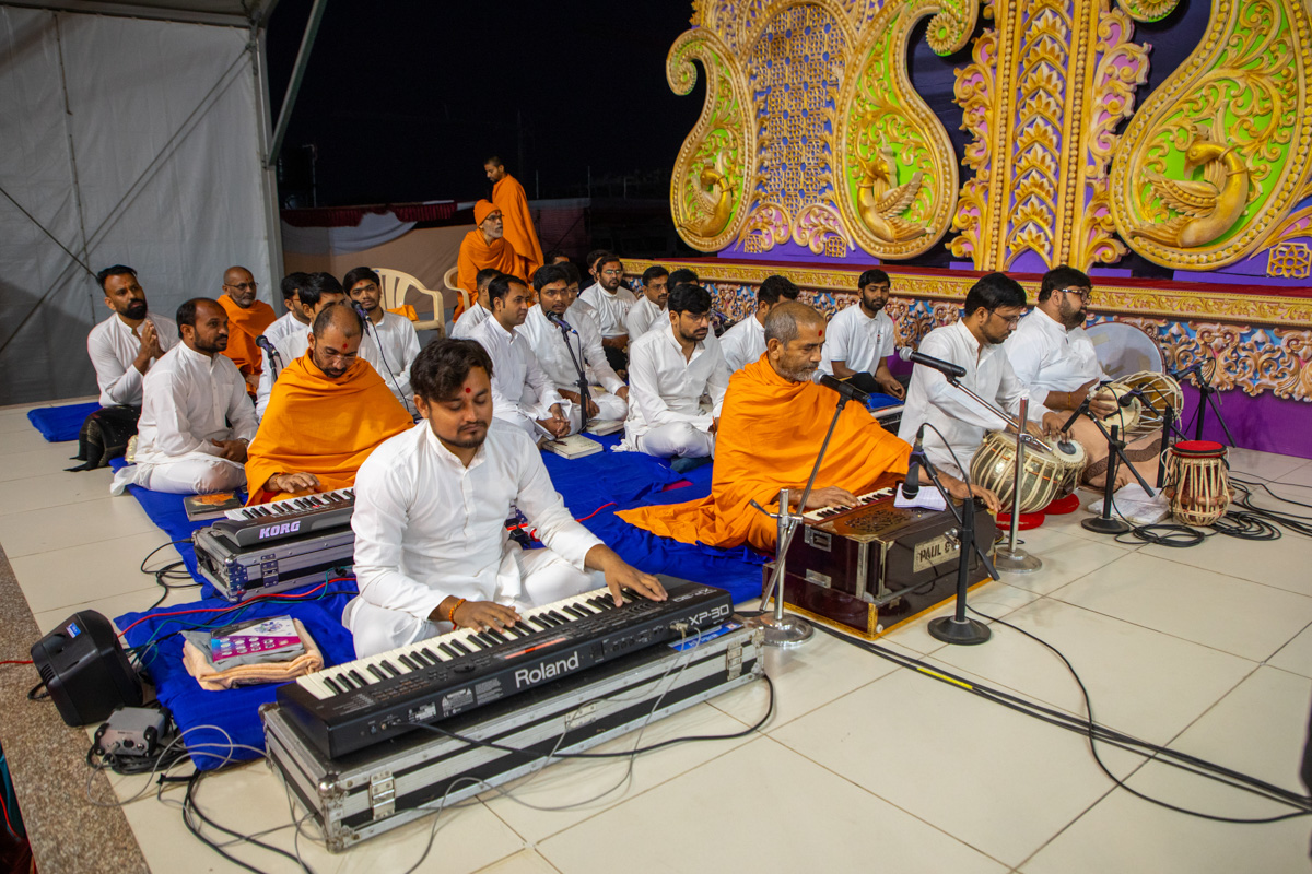 Swamis and youths sing kirtans in Swamishri's daily puja