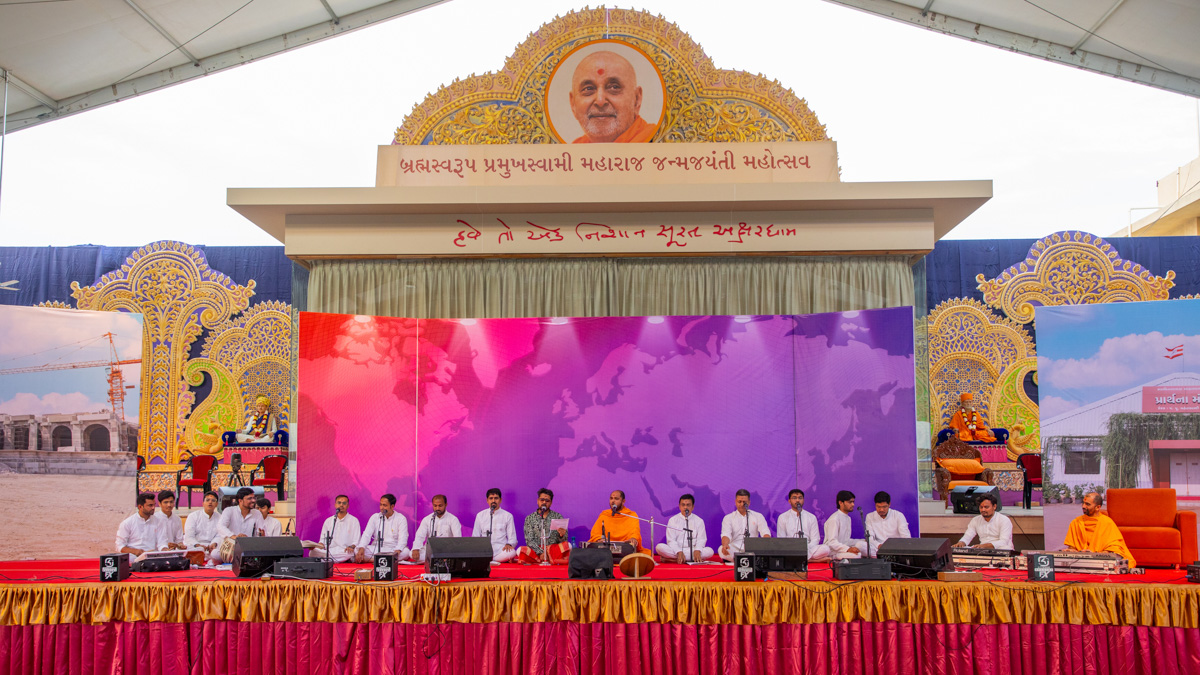 A swami and youths sing kirtans in the evening assembly