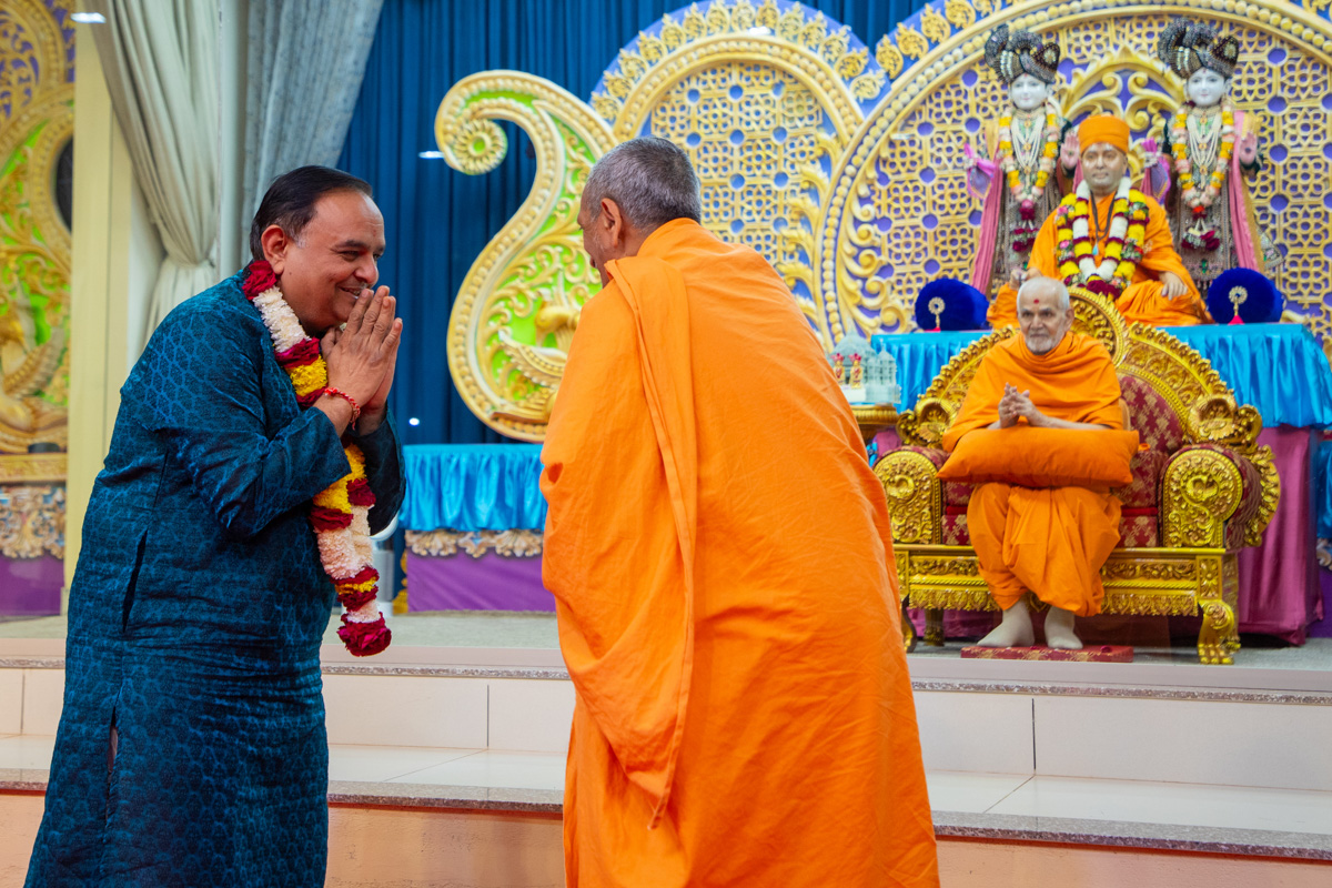 Uttamprakash Swami honors an invited guest with a garland
