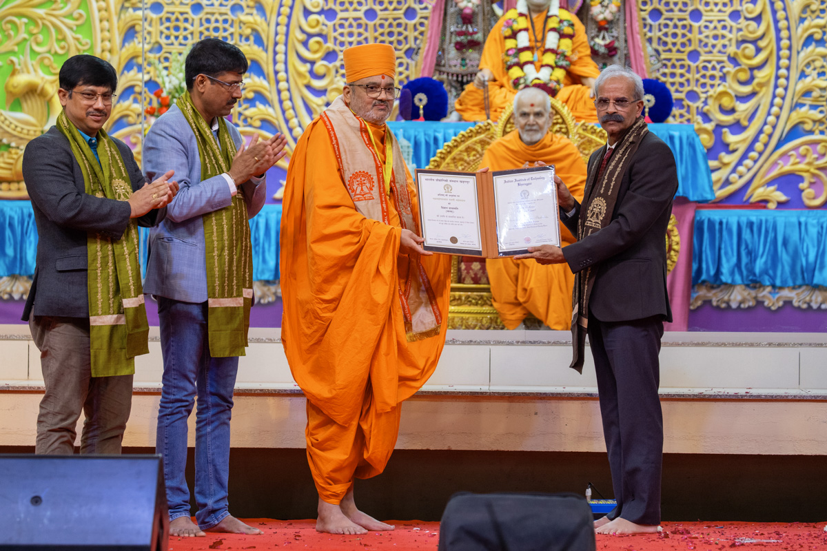 Prof. Virendra Kumar Tewari and dignitaries present a certificate to Bhadresh Swami