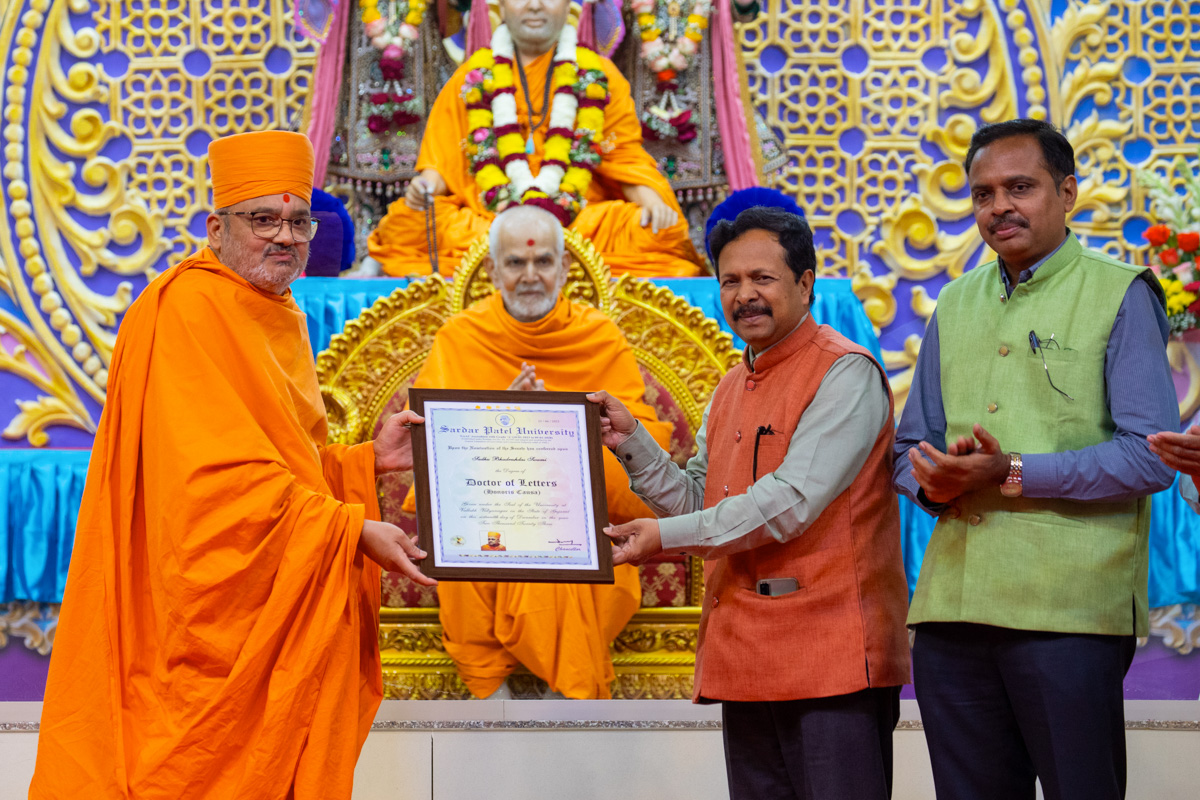 Prof. Niranjanbhai Patel presents a Doctor of Letters (D.Litt. Honoris Causa) certificate to Bhadresh Swami
