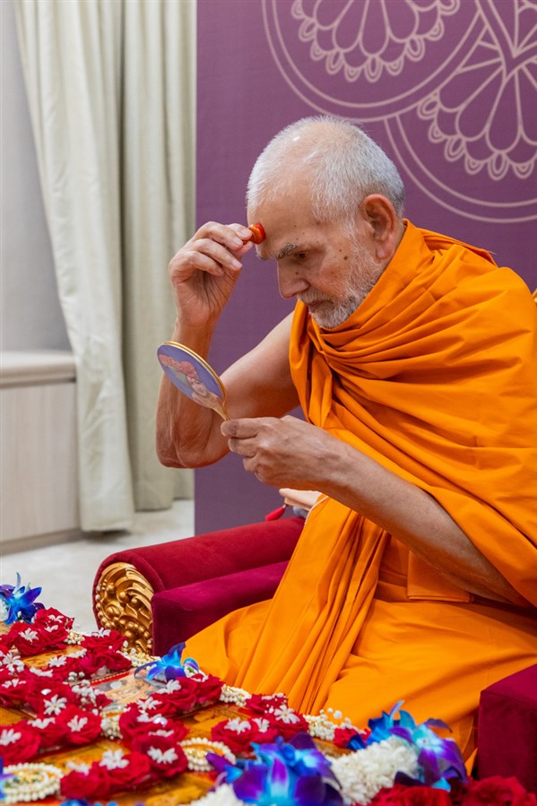 Swamishri applies a chandlo on his forehead