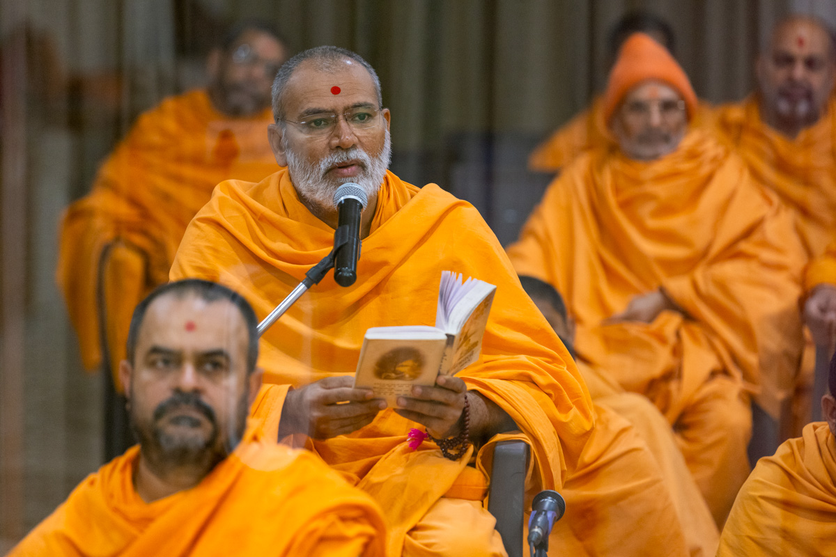 A swami sings a kirtan in Swamishri's puja
