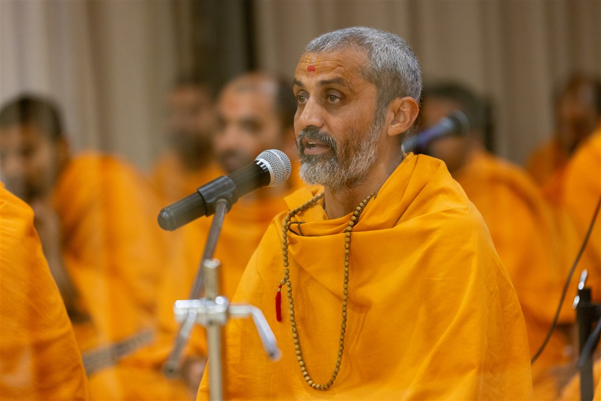 A swami leads everyone in reciting the sadhana mantra and daily prayer in Swamishri's puja