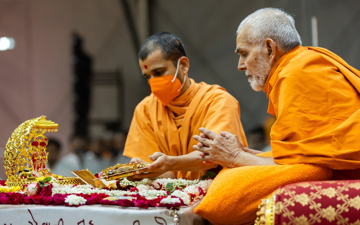 A swami offers thal to Shri Harikrishna Maharaj and Shri Gunatitanand Swami Maharaj