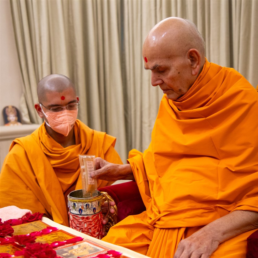 Swamishri sanctifies water with the holy relics of Bhagwan Swaminarayan and the Guru Parampara