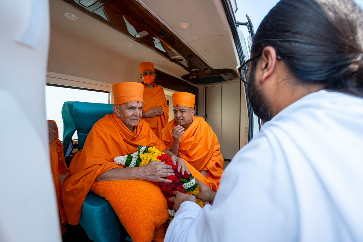 Shri Atmaprit Nemiji welcomes Swamishri with a garland