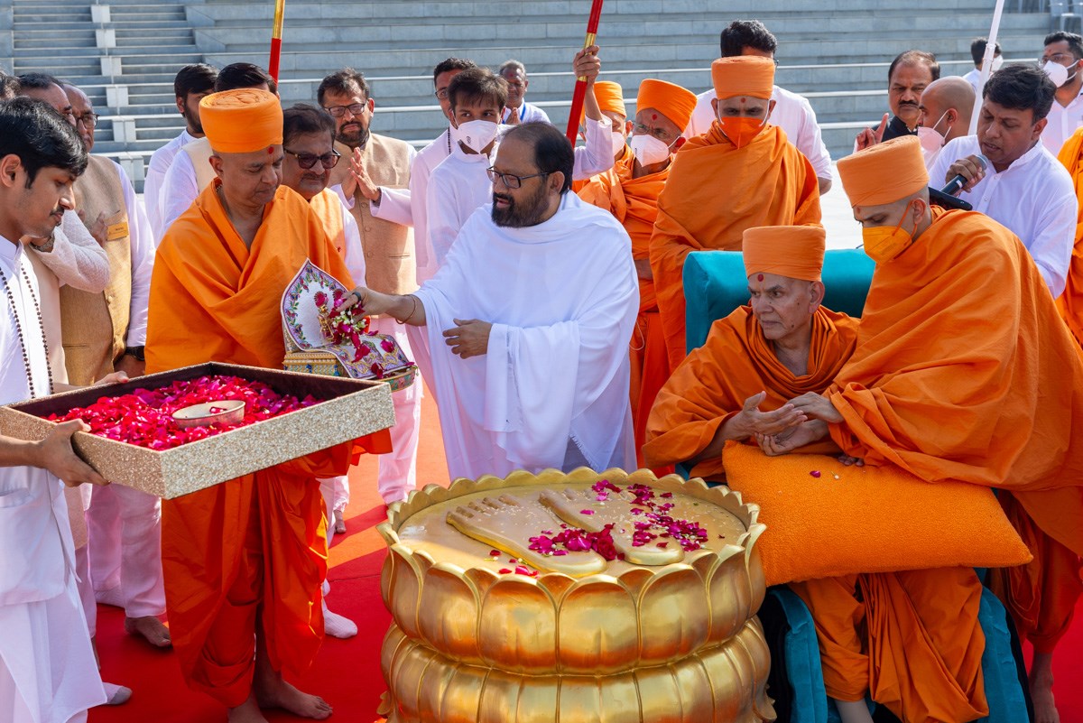 Pujya Gurudevshri Rakeshji offers flower petals to Shri Harikrishna Maharaj and Shri Gunatitanand Swami Maharaj