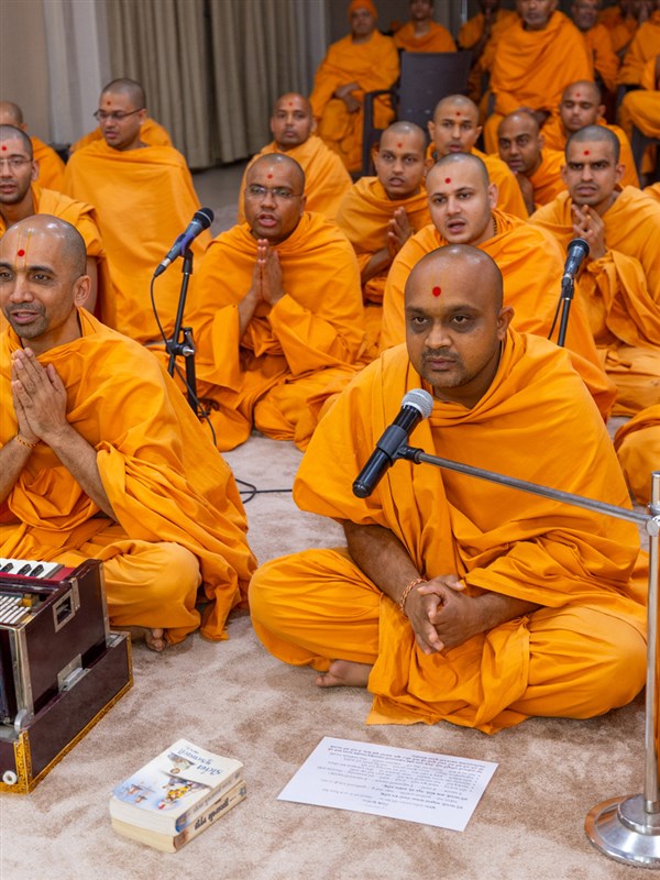 A swami leads everyone in reciting the sadhana mantra and daily prayer in Swamishri's puja