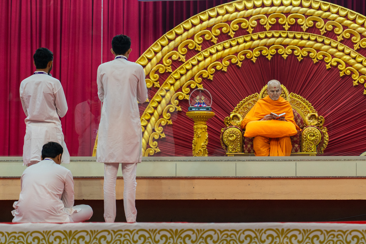 Youths lead everyone in reciting the sadhana mantra and daily prayer in Swamishri's puja