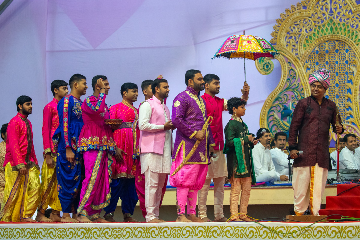 Youths perform a parade before Swamishri