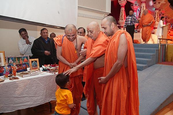  Swamishri blesses a young child
