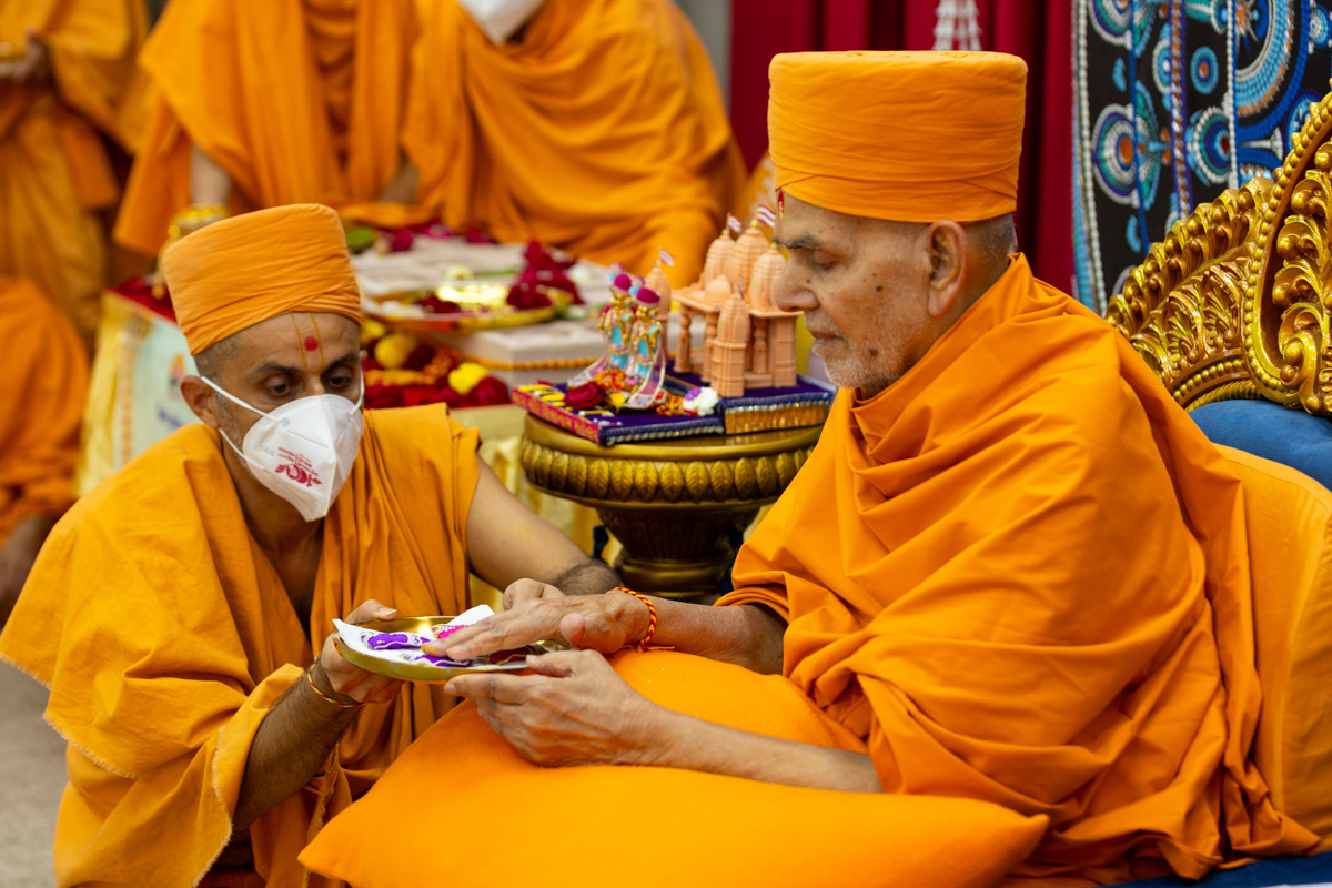 Swamishri sanctifies garments for Thakorji