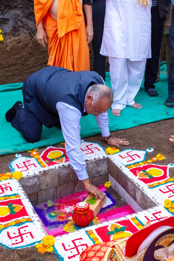 A devotee places a sanctified brick