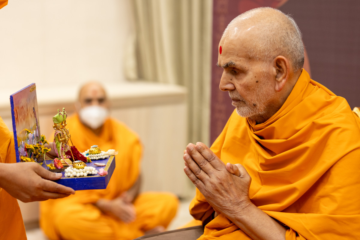 Swamishri engrossed in darshan of Shri Harikrishna Maharaj and Shri Gunatitanand Swami Maharaj