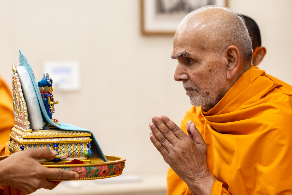 Param Pujya Mahant Swami Maharaj engrossed in darshan of Shri Harikrishna Maharaj and Shri Gunatitanand Swami Maharaj