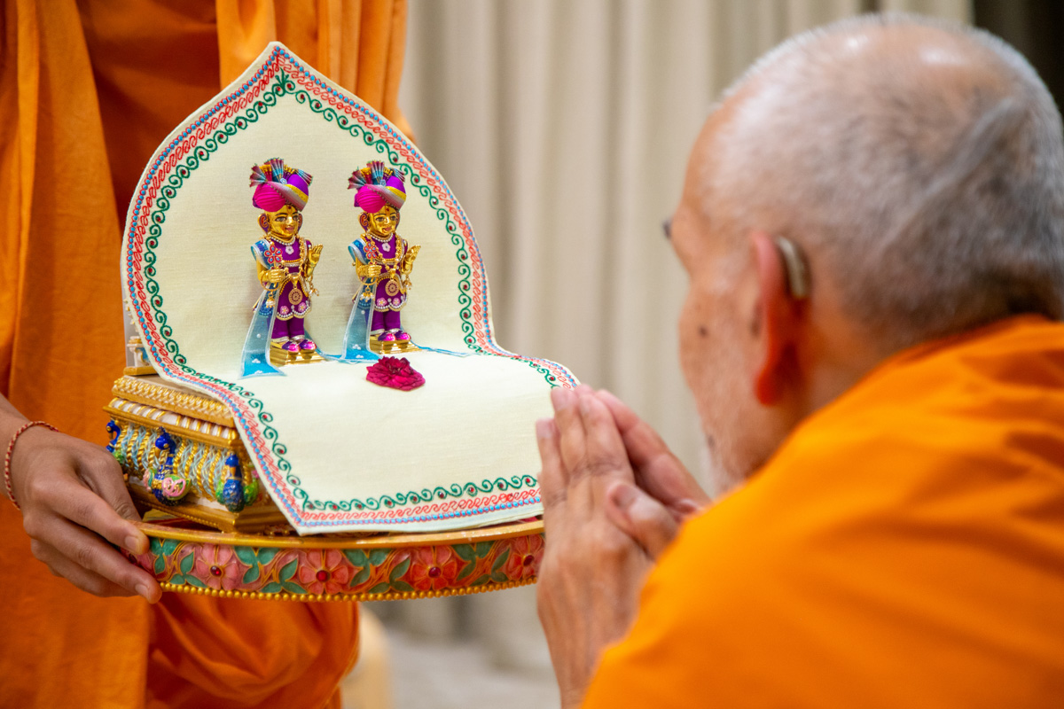 Swamishri engrossed in darshan of Shri Harikrishna Maharaj and Shri Gunatitanand Swami Maharaj 