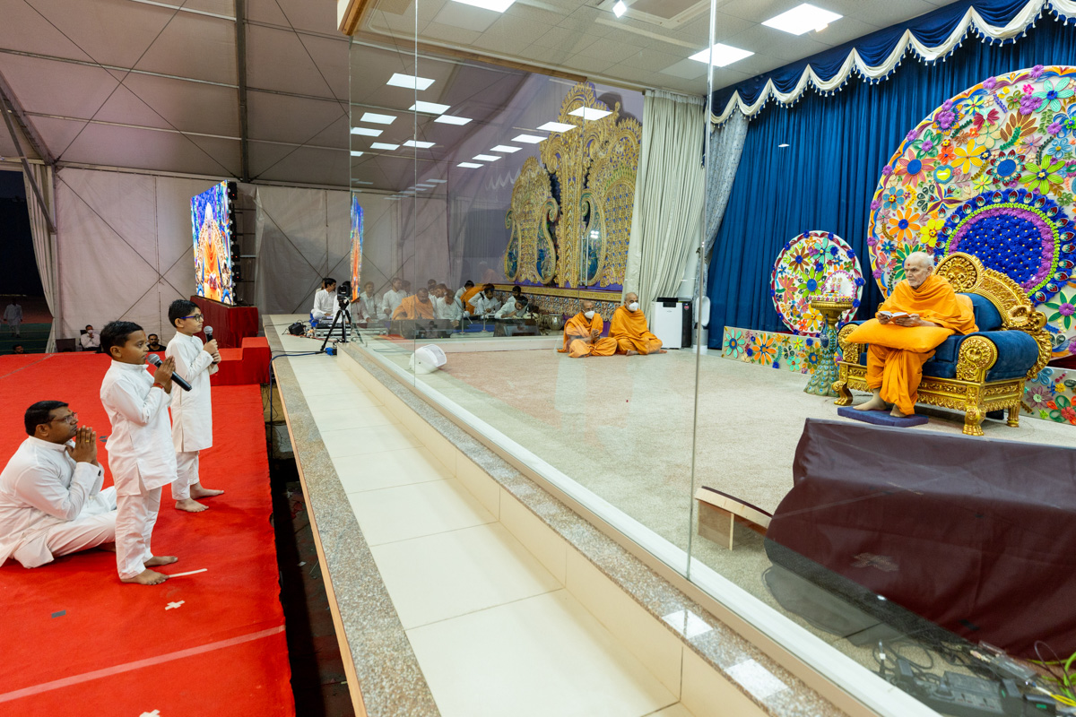 Children lead everyone in reciting the sadhana mantra and daily prayer in Swamishri's puja