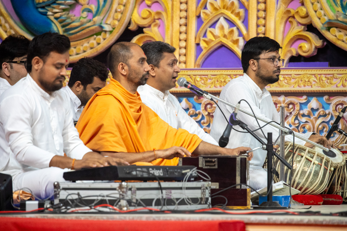 A devotee sings a kirtan in Swamishri's daily puja