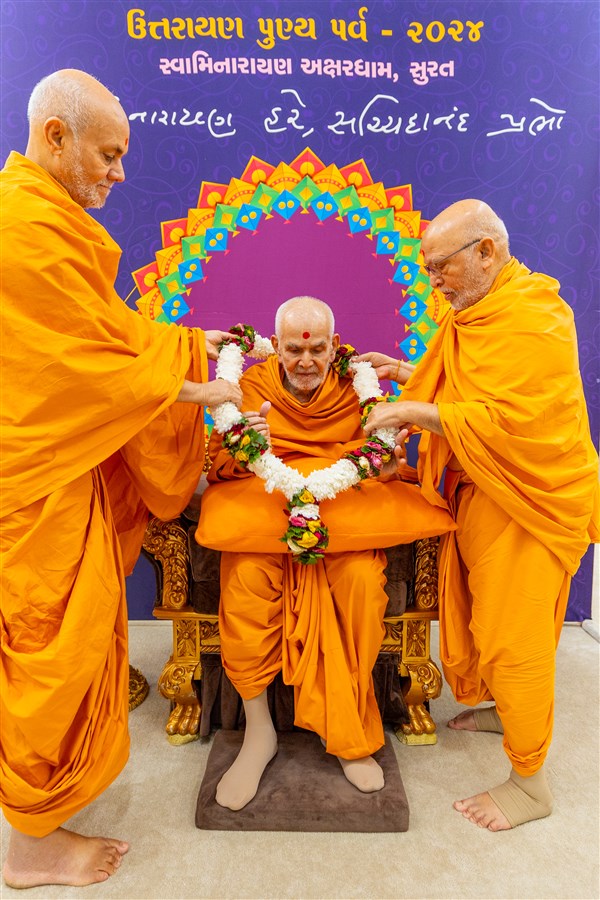 Pujya Viveksagar Swami and Pujya Ghanshyamcharan Swami honor Swamishri with a garland