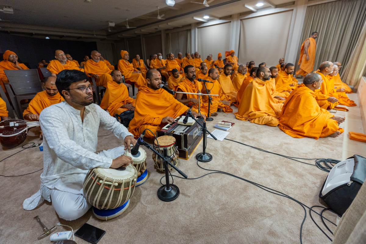 Swamis sing kirtans in Swamishri's daily puja