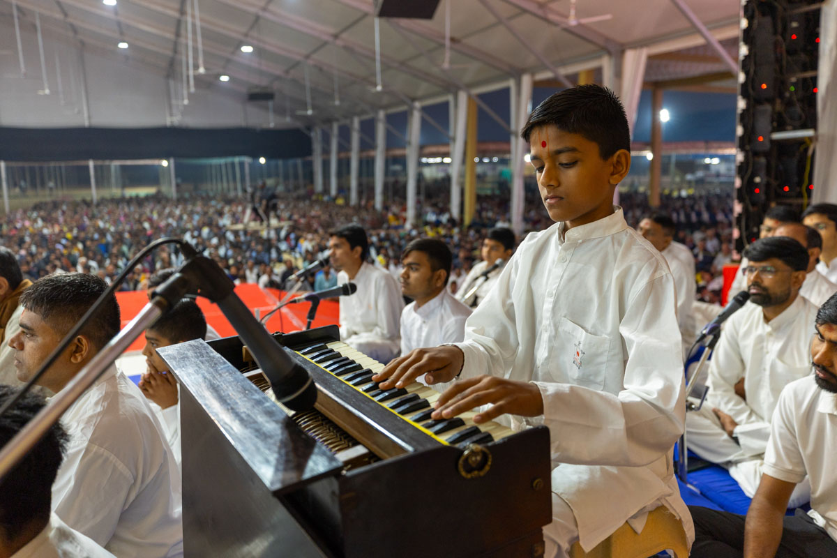 A child plays a harmonium in Swamishri's daily puja