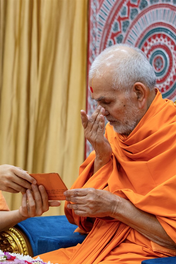 Swamishri reverently touches the holy feet of Shri Akshar-Purushottam Maharaj