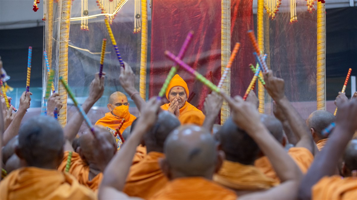 Swamis playing the traditional ras around Swamishri